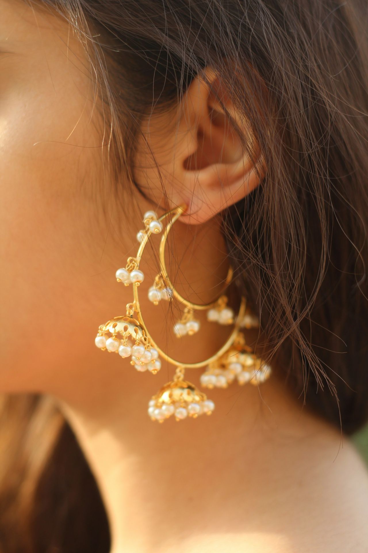 a close up of a person wearing a pair of earrings